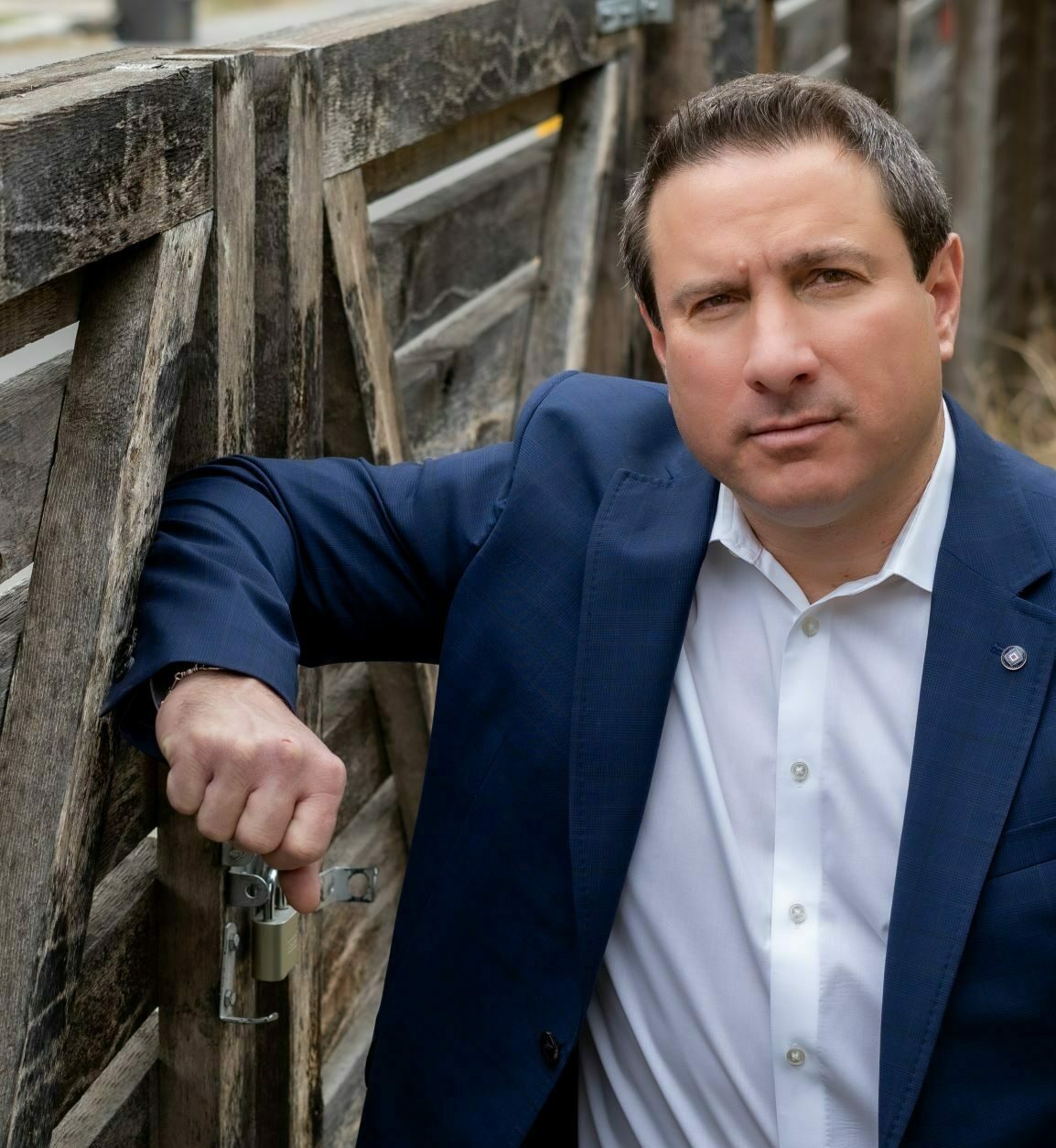 john lopez posed leaning against fence
